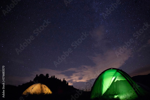 Tent camping under starry night.