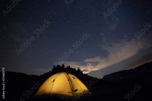Tent camping under starry night.