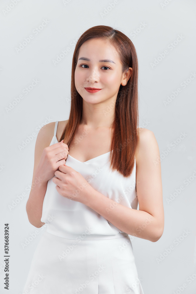 Beautiful young sexy woman in a light gray dress posing against a white wall Beautiful young sexy woman in a light gray dress posing against a white wall