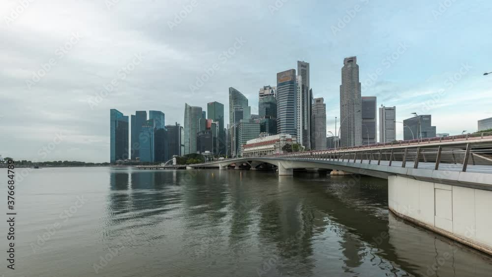 Esplanade bridge and downtown core skyscrapers in the background Singapore night to day transition timelapse. Illuminated towers reflected in water Esplanade bridge and downtown core skyscrapers in the background Singapore night to day transition timelapse. Illuminated towers reflected in water