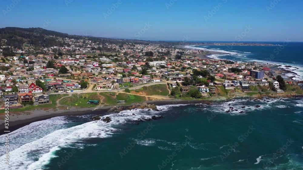 aerial: view of infiernillo beach in the city of pichilemu also overlooking the town with black sand beach and houses on the beach drone shot chile pichilemu punta de lobos en colchagua cardenal caro