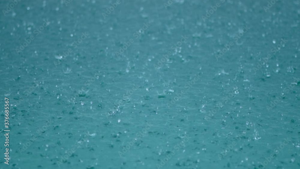 tropical rain water drops fall into clear blue lake or pool