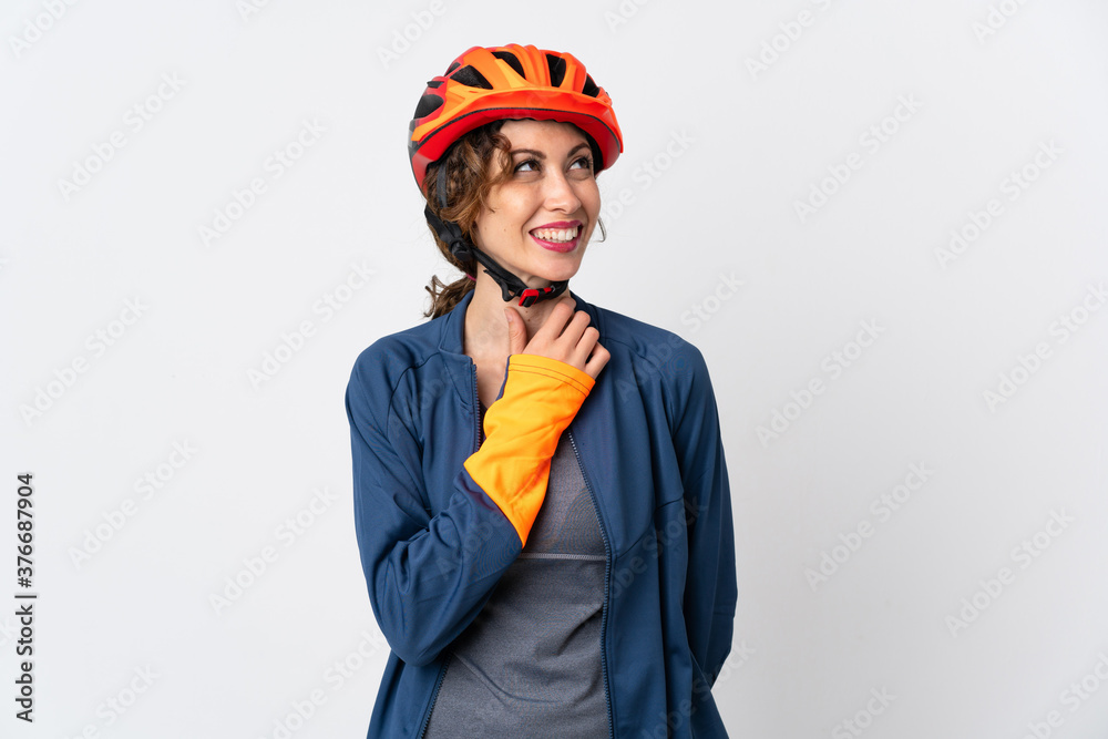 Young cyclist woman isolated on white background looking up while smiling Young cyclist woman isolated on white background looking up while smiling