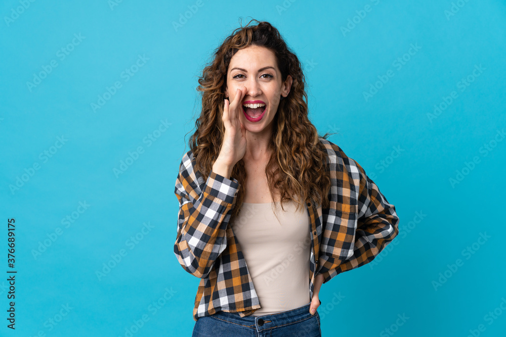 Young caucasian woman isolated on blue background shouting with mouth wide open Young caucasian woman isolated on blue background shouting with mouth wide open