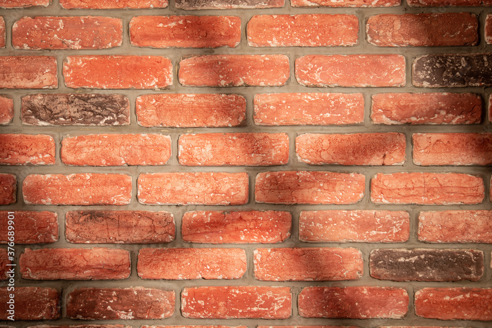 Fototapeta premium Shadow and light from a window on a red brick wall