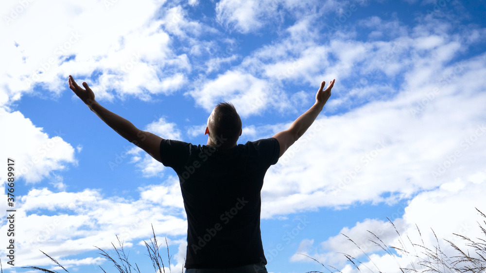 Reach out for the sky - A man opens out his arms facing a vibrant misty sky standing on top of a hill. Reach out for the sky - A man opens out his arms facing a vibrant misty sky standing on top of a hill.