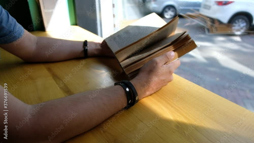 Hands of man flipping through a book backwards