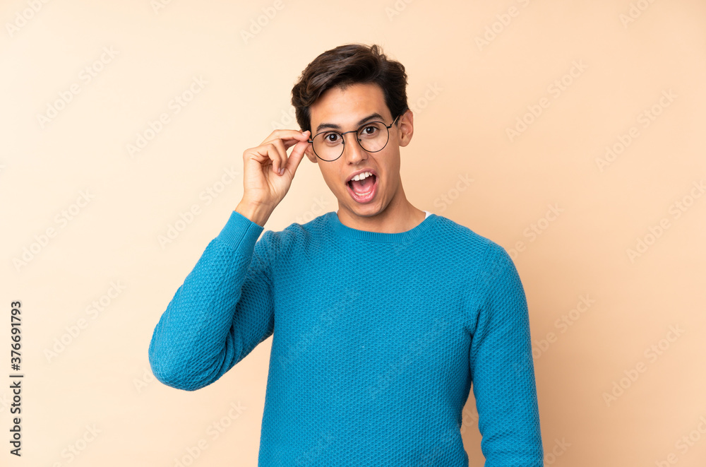 Man over isolated background with glasses and surprised Man over isolated background with glasses and surprised