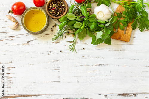 Ingredients for cooking. Herbs spices  olive oil and vegetables on a wooden table. Top view flat lay background. Copy space.