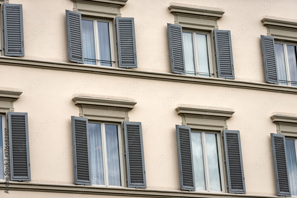 Facade of a generic house with windows and grey shutters in Florence, Tuscany, Italy, Europe