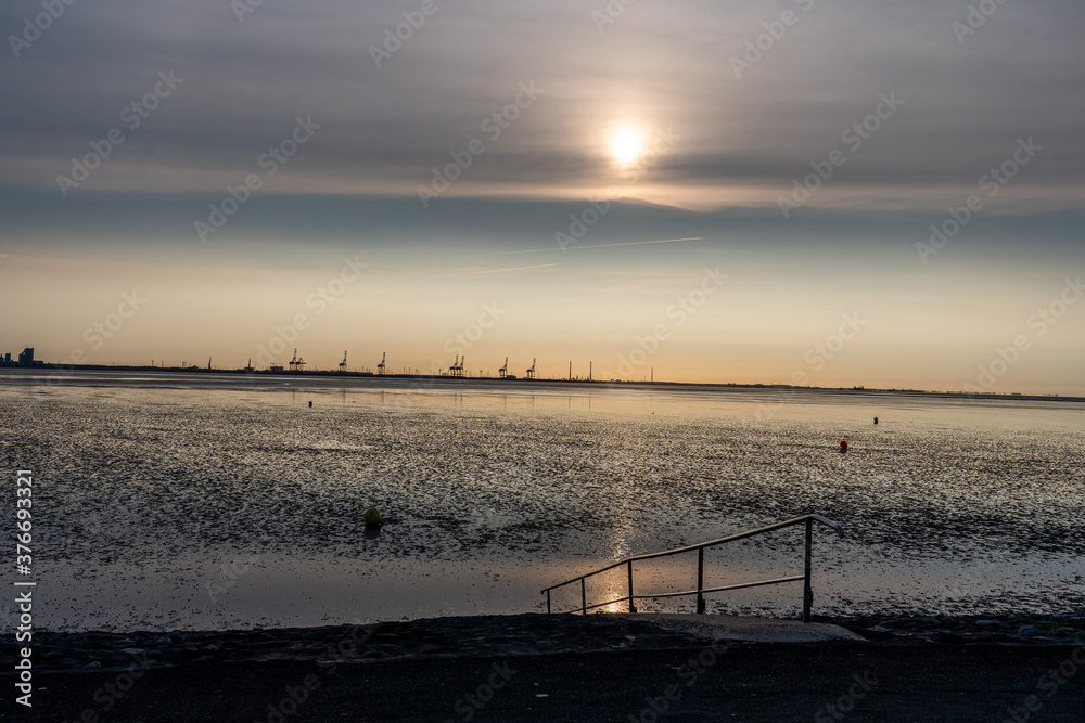 view on the wadden sea of the north sea at low tide at sunset near tossen