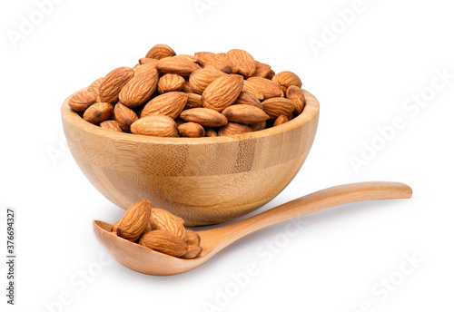 Fresh almonds nut in wooden bowl with spoon isolated on white background with clipping path.