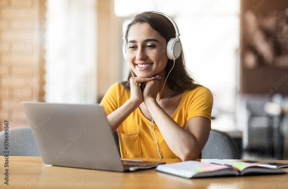 Smiling arab girl having video call while resting at cafe Smiling arab girl having video call while resting at cafe