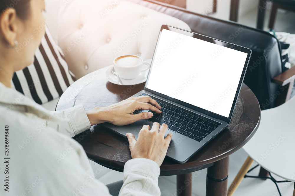 Fototapeta premium computer mockup blank screen.hand woman work using laptop with white background for advertising,contact business search information on desk at coffee shop.marketing and creative design