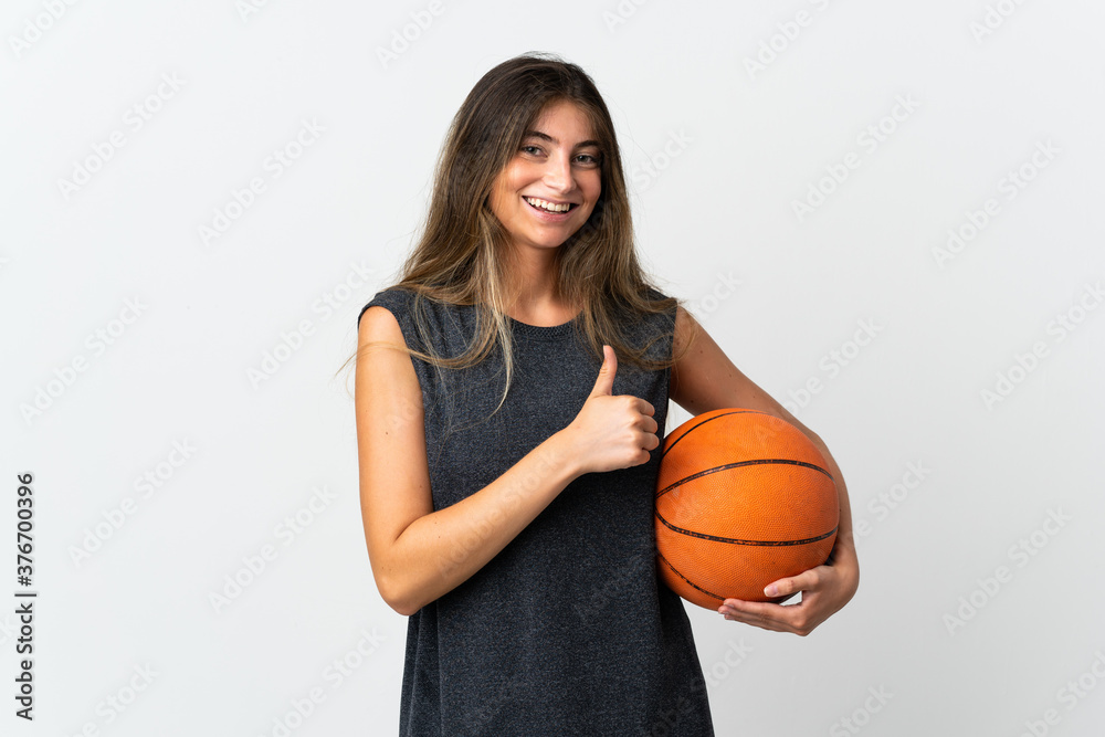 Young woman playing basketball isolated on white background giving a thumbs up gesture