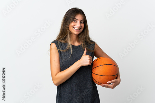 Young woman playing basketball isolated on white background giving a thumbs up gesture