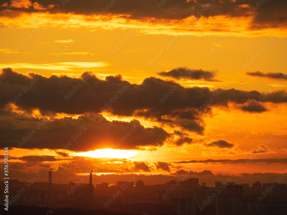 Colorful cloudy epic sky on sunset over the panoramic dark silhouette of the Moscow city skyline