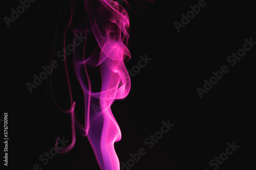 Fototapeta Naklejka Na Ścianę i Meble -  Purple smoke on a black background. Colored smoke. Incense stick smoke illuminated by purple light.