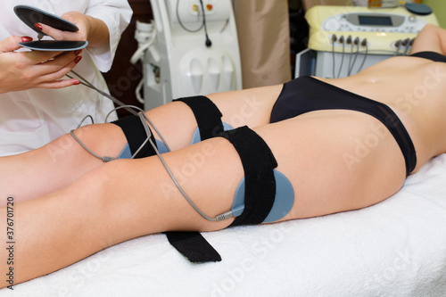 Massage by electrical muscle stimulation of the thigh muscles. Anti-cellulite massage by myosthulation.