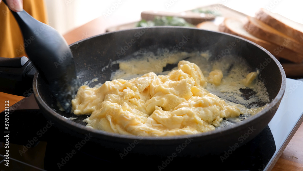Scrambled eggs in cooking pan. Process of cooking scrambled eggs