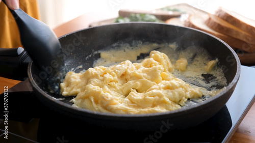 Tableau sur toile Scrambled eggs in cooking pan. Process of cooking scrambled eggs