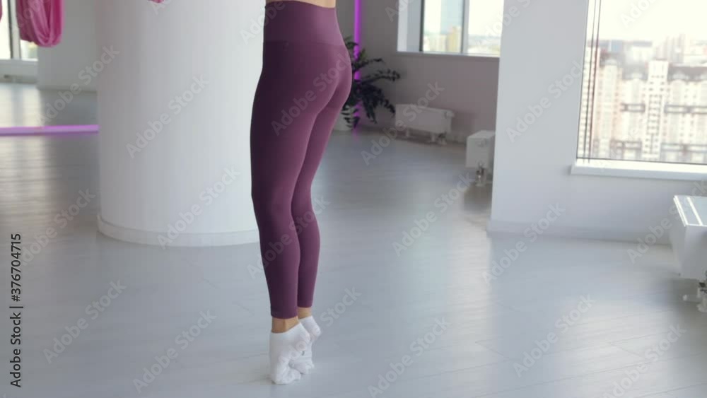 A young athletic girl does yoga on a hammock, exercises for health. Workout in the gym with panoramic Windows. A young athletic girl does yoga on a hammock, exercises for health. Workout in the gym with panoramic Windows.