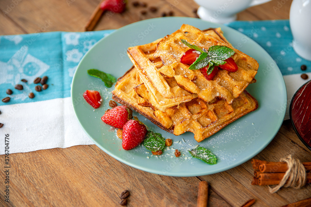 Breakfast with waffles, strawberries, mint and cinnamon