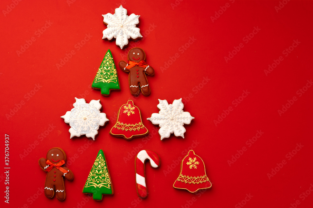 Christmas gingerbread cookies on red background top view