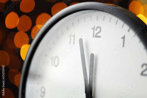 Canvas Print New Year eve concept with alarm clock against blurred garland