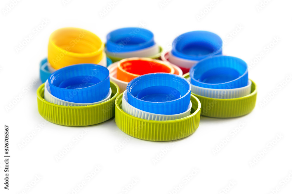 Composition of plastic caps on a white background. Top view of recycled plastic bottle caps. Separate garbage collection. Recycling of plastic for prosthetics. Composition of plastic caps on a white background. Top view of recycled plastic bottle caps. Separate garbage collection. Recycling of plastic for prosthetics.