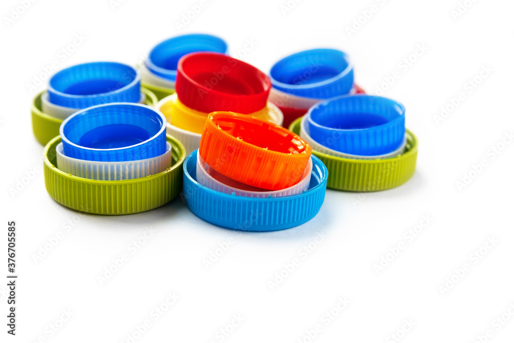 Recycled plastic bottle caps. Colorful caps of plastic bottles on a white background. Separate garbage collection. Recycling of plastic for prosthetics. Recycled plastic bottle caps. Colorful caps of plastic bottles on a white background. Separate garbage collection. Recycling of plastic for prosthetics.