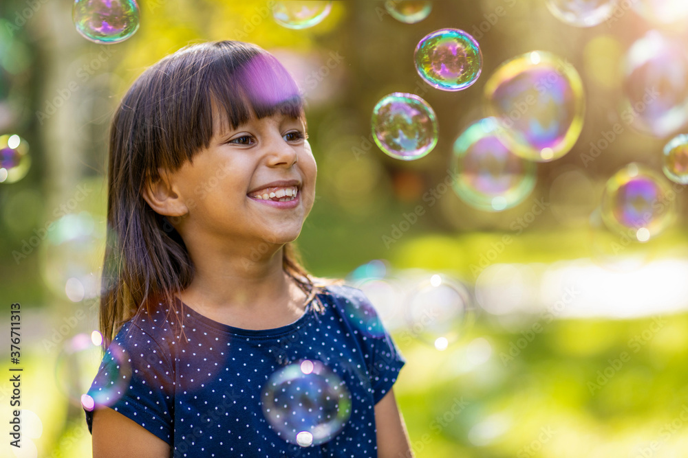 Girl playing with soap bubbles outdoors
Girl playing with soap bubbles outdoors