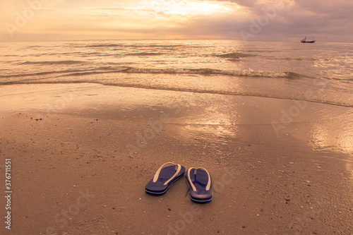 Beautiful waves on the beach and blue sandals with in sunrise. 