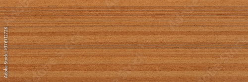 Beautiful brown teak veneer background for your interior. Natural wood texture, pattern of a long veneer sheet, plank.