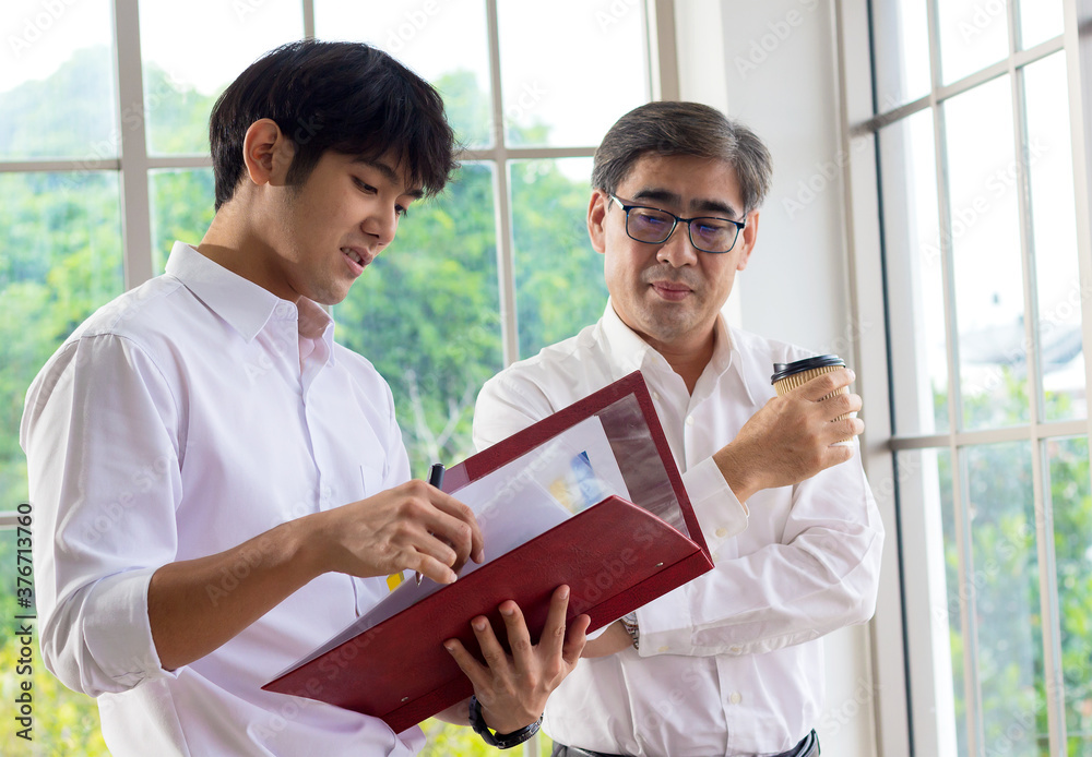Young businessman holds a portfolio to report the earnings to the president. business man holds coffee cup Young businessman holds a portfolio to report the earnings to the president. business man holds coffee cup
