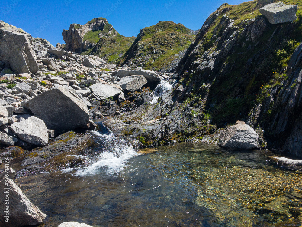 Panoramic view of alpine landscape with a small waterfall. Panoramic view of alpine landscape with a small waterfall.