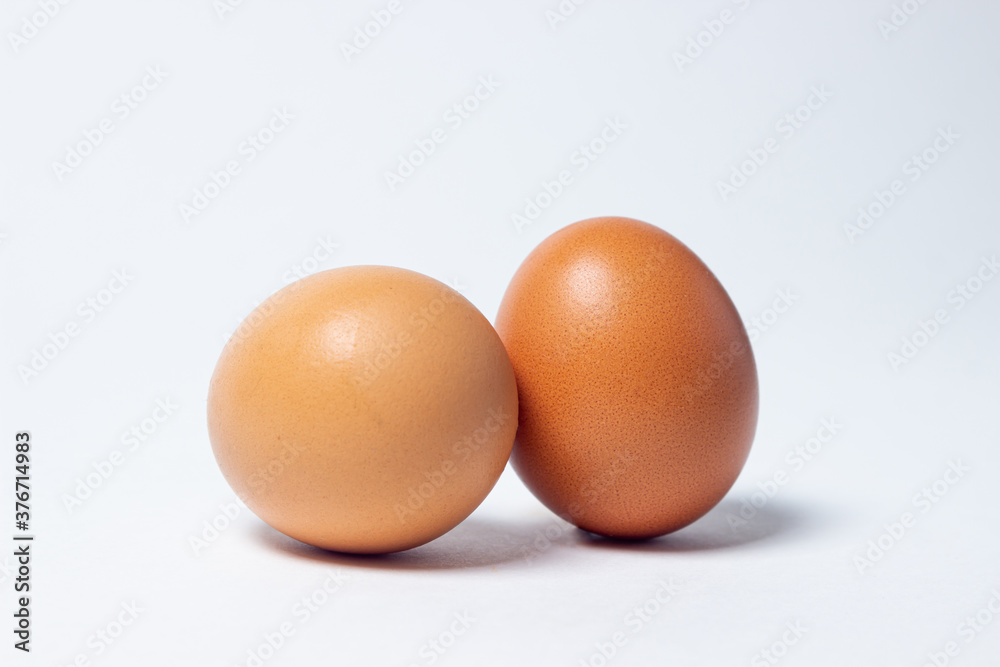 Eggs on a white background. Two chicken eggs lie next to each other