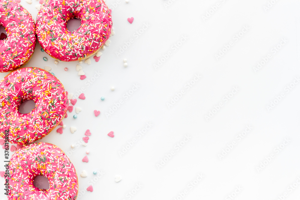 Pink berry donuts flat lay, top view. Glazed and sprinkles doughnuts Pink berry donuts flat lay, top view. Glazed and sprinkles doughnuts