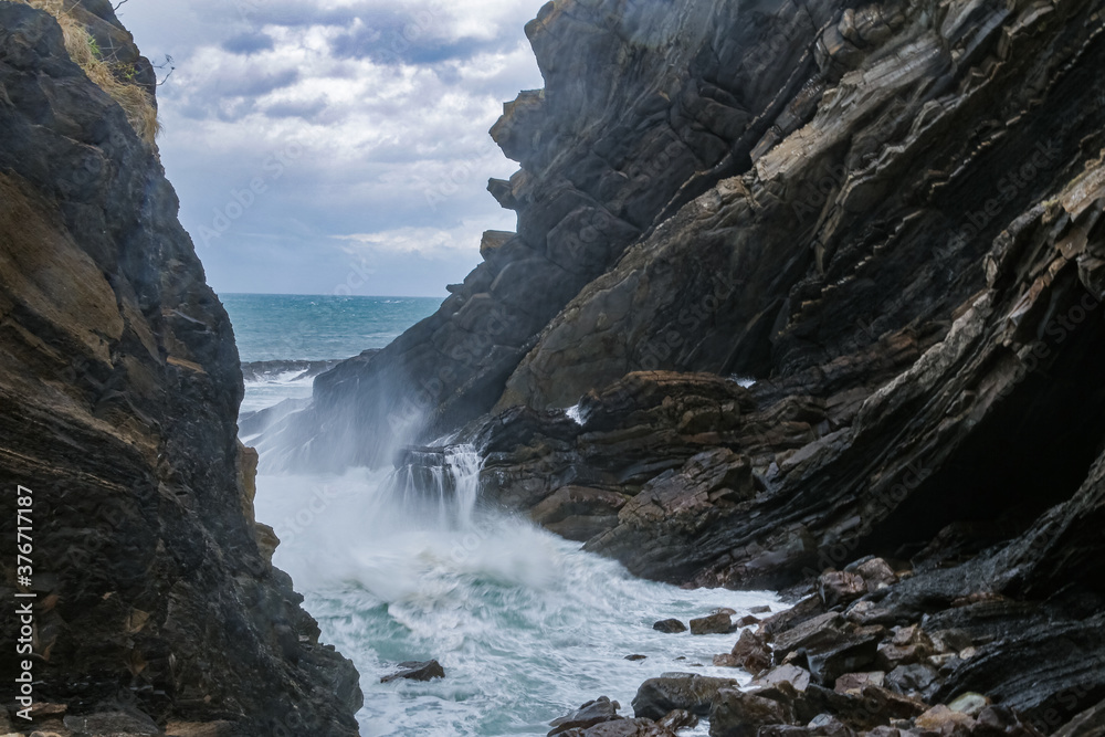 Olas de temporal de tormenta rompiendo en acantilado rocoso