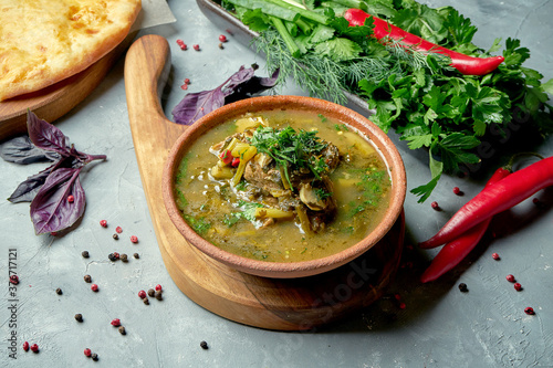 Fototapeta Naklejka Na Ścianę i Meble -  CLose up on Chakapuli - traditional Georgian meat stew from lamb or beef with plum sauce tkemali.