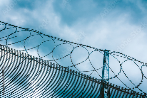 Barbed wire fence on a blue dramatic sky