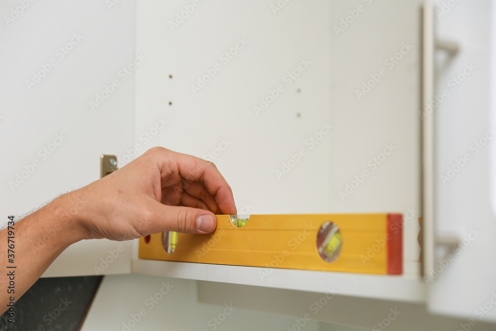 man's hand is using construction level in refurbishment man's hand is using construction level in refurbishment