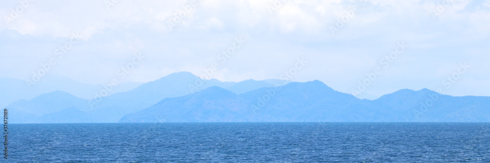 Obraz premium Blue sea with mountains and sky banner background.