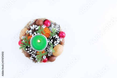 Christmas decorative burning candle and Christmas tree decorations. White background.