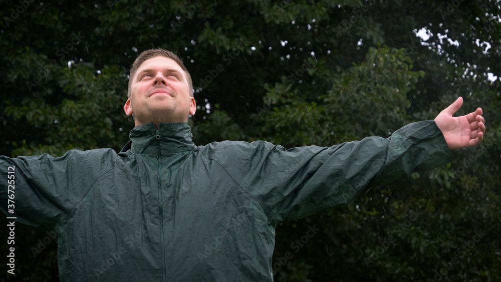 Portrait of a man smiling happy in the rain and breathing air of freedom, dreams, and love for nature. Concept of: lifestyle, nature, freedom, rain and happiness. Portrait of a man smiling happy in the rain and breathing air of freedom, dreams, and love for nature. Concept of: lifestyle, nature, freedom, rain and happiness.