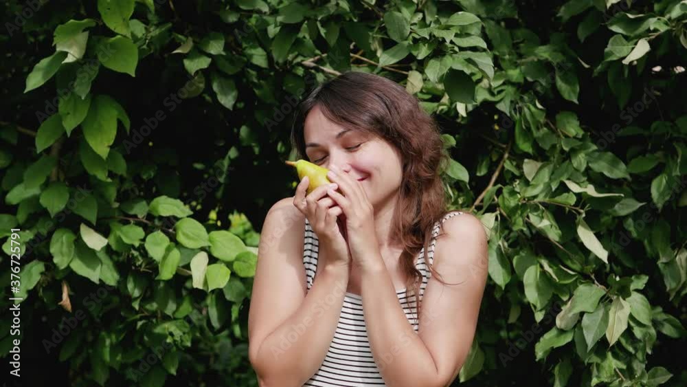 attractive young woman eating a pear on a wood background. healthy food. attractive young woman eating a pear on a wood background. healthy food.