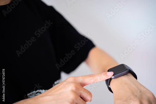 Closeup shot smartwatch, Hand wearing elegant smartwatch is a luxurious accessory. A woman finger touching a smartwatch