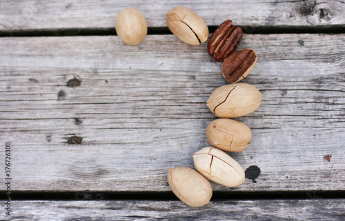Pecan Nuts on wooden background, top view with copyspace. Close up veiw of nuts.