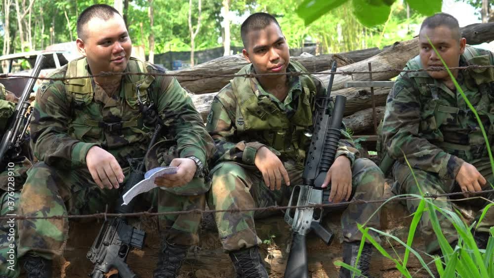 Team of army soldier with machine gun moving in the forest,Thai militia soldier in combat uniforms in the wood,Wander the patrol sloping in the rainforest. Team of army soldier with machine gun moving in the forest,Thai militia soldier in combat uniforms in the wood,Wander the patrol sloping in the rainforest.