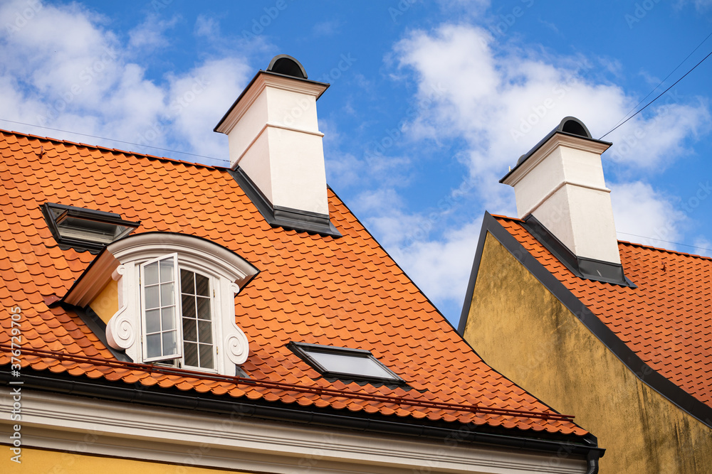 Baroque architecture style dormer window on orange tile roof of Jacob's Barracks in old town of Riga (Vecriga), Latvia.
